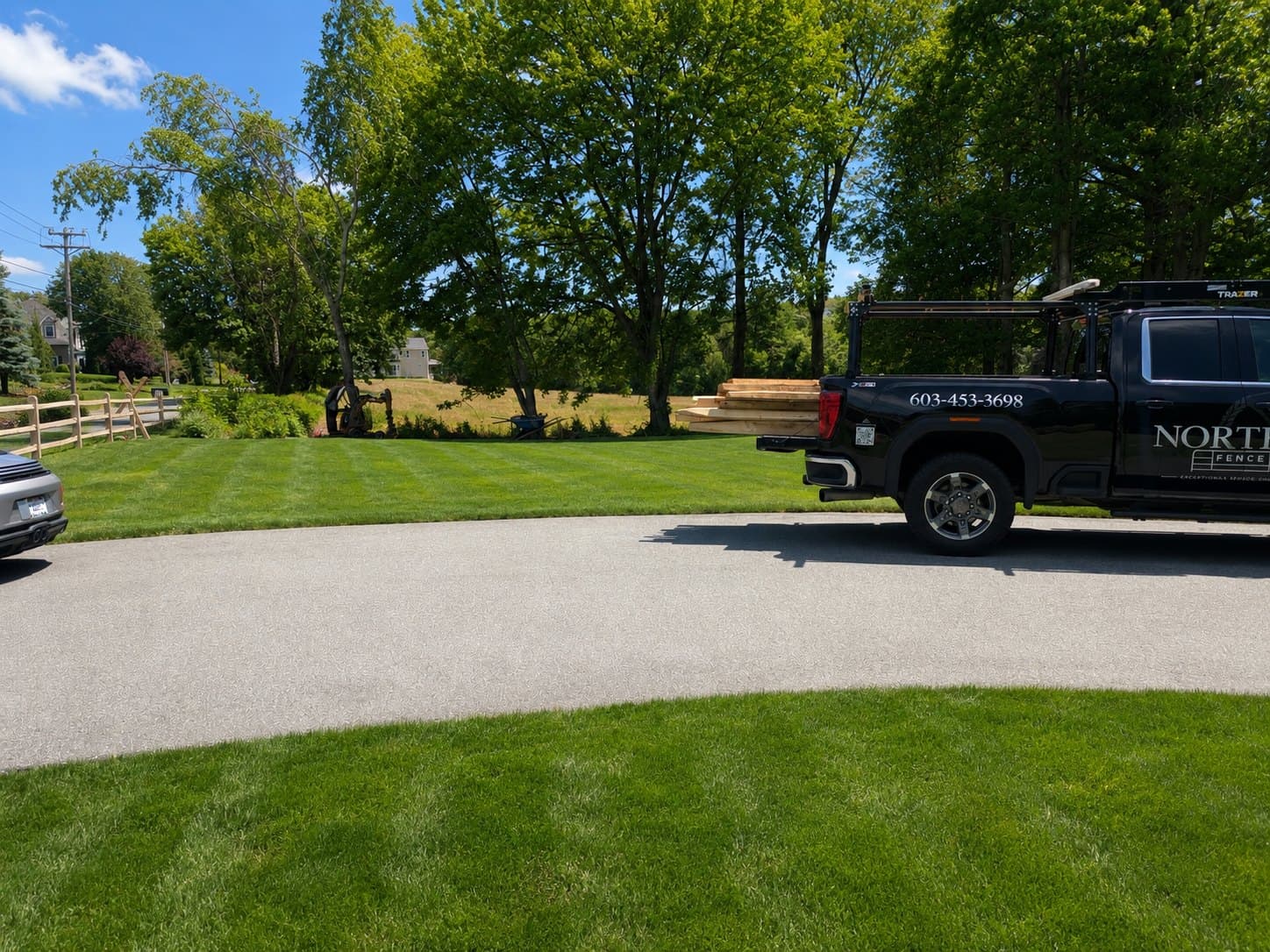 Northstar Fence & Rail branded truck loaded with lumber at a New England job site